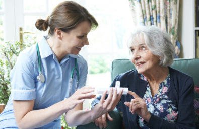 Nurse Advising Senior Woman On Medication At Home
