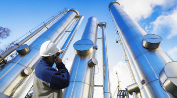oil-worker, engineer with large oil and gas pipes, pipelines, sl