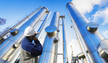 oil-worker, engineer with large oil and gas pipes, pipelines, sl